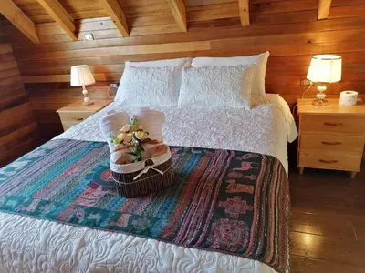 a bedroom with a bed with a basket of flowers on it at La Cabaña de Mari in Oxapampa