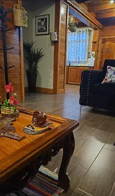 a living room with a table and a couch at La Cabaña de Mari in Oxapampa