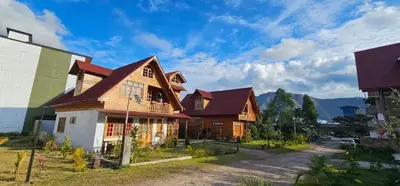 a house with a mountain in the background at La Cabaña de Mari in Oxapampa