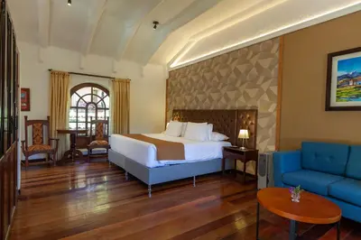 a hotel room with a bed and a blue couch at Inti Punku Valle Sagrado Hotel in Urubamba