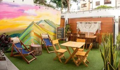 a room with a table and chairs and a mural at Rainbow Hostel in Lima