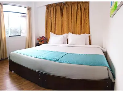 a bedroom with a large bed with a window at Runa Apartamentos in Cusco