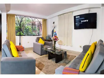 a living room with two couches and a tv at Runa Apartamentos in Cusco
