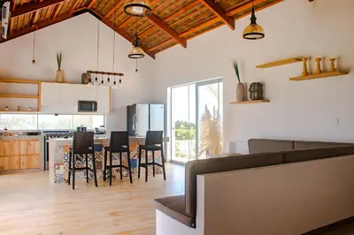 a kitchen and living room with a table and chairs at HOP PRAIA exclusiva laguna y playa en Chincha in Chincha Baja