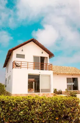 a white house with a brown roof at HOP PRAIA exclusiva laguna y playa en Chincha in Chincha Baja