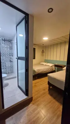 a room with two beds and a sliding glass door at Casa Kutimuy in Ayacucho