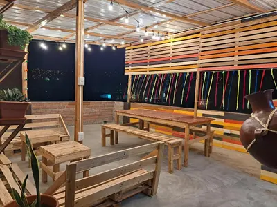a patio with wooden benches and colorful walls at Casa Kutimuy in Ayacucho