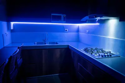 a kitchen with a stove and a blue light at Casa Kutimuy in Ayacucho