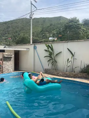 two people riding on an infogie board in a swimming pool at Casa completa piscina 3 Habitaciones en Chanchamayo in La Merced