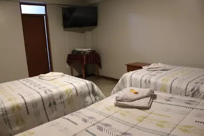 a room with two beds with towels on them at LA CASA DEL VISITANTE in Cusco