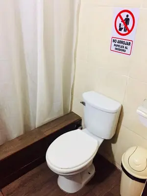 a bathroom with a toilet and a sign that says no animalhibited at KORICANCHA in Lima