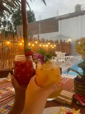 a person holding two drinks in their hands at Samay77 Ica in Ica