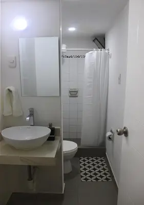 a bathroom with a sink and a toilet and a mirror at Acogedor departamento en el centro de Barranco in Lima