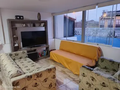a living room with two couches and a flat screen tv at Acogedor departamento en el centro de Barranco in Lima