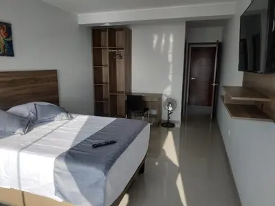 a bedroom with a bed and a desk and a chair at Hotel Terrazas Del Mar in Huacho