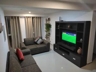 a living room with a couch and a tv at Apart Cusco 