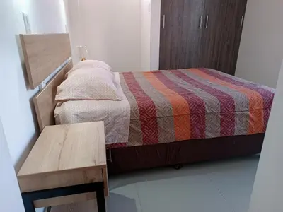 a small bedroom with a bed and a wooden table at Apart Cusco 