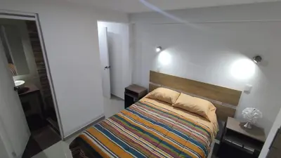a small bedroom with a bed and a mirror at Apart Cusco 
