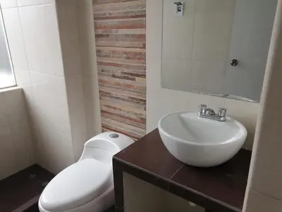 a bathroom with a white toilet and a sink at Apart Cusco 