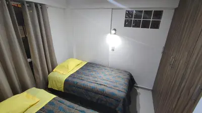 a small room with two beds and a lamp at Apart Cusco 