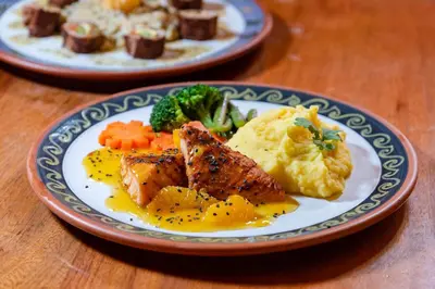two plates of food with meat and vegetables on a table at Tierra Viva Ollantaytambo in Ollantaytambo