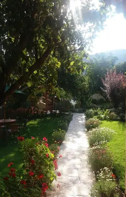 a path in a garden with flowers at IORANA HOTEL Urubamba in Urubamba