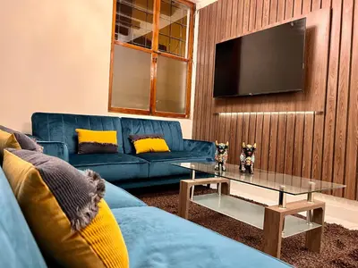 a living room with a blue couch and a table at Casona Plaza Hotel Cusco in Cusco