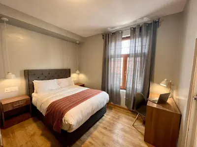 a bedroom with a bed and a desk and a window at Casona Plaza Hotel Cusco in Cusco