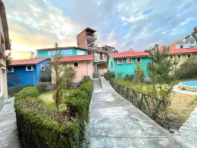 a row of colourful houses with a fence at Mi Pueblito Lodge in Huancayo