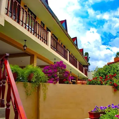 a balcony with flowers on the side of a building at Mi Pueblito Lodge in Huancayo