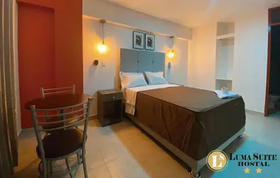a bedroom with a bed and a chair and a table at LUMA SUITE in Lima