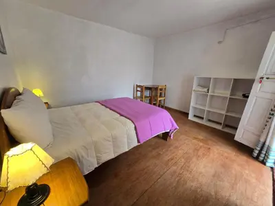 a bedroom with a bed with a purple blanket at Barrio Inka B&B in Cusco
