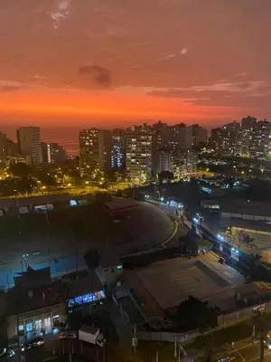 a city lit up at night with a city at Chic & Ocean View Apartment in Lima