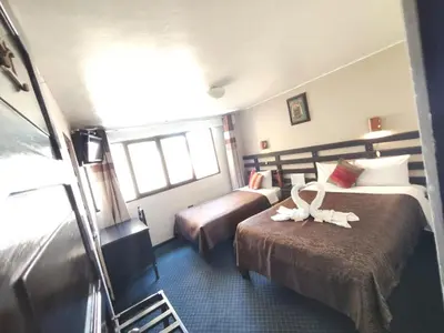 a hotel room with two beds and a window at SQ Estancia Del Inca in Cusco