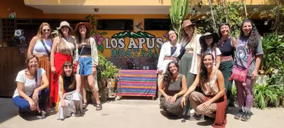 a group of people posing for a picture in front of a store at Los Apus Ollantaytambo in Ollantaytambo