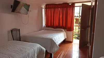 a bedroom with two beds and a window with a view at Los Apus Ollantaytambo in Ollantaytambo