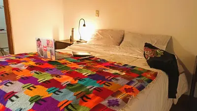 a bed with a colorful quilt on top of it at Los Apus Ollantaytambo in Ollantaytambo
