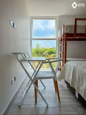 a desk and a chair in a room with a window at HOP BUZIOS exclusiva oasis y playa en Chincha in Chincha Baja
