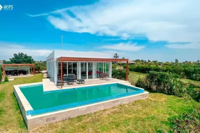 a swimming pool in a yard with a house at HOP BUZIOS exclusiva oasis y playa en Chincha in Chincha Baja