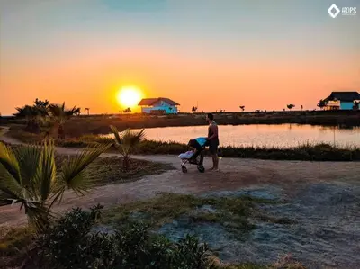 a man pushing a baby in a stroller at sunset at HOP LAGO & MAR exclusiva en playa de chincha in Chincha Baja