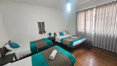 a room with two beds and a couch in it at Natural B&B Guest House in Cusco