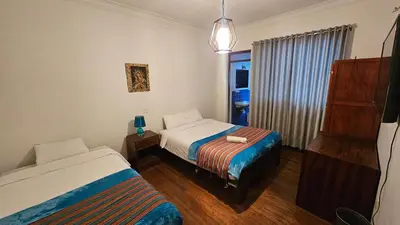 a small bedroom with two beds and a window at Natural B&B Guest House in Cusco