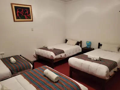 a room with three beds in a room at Natural B&B Guest House in Cusco