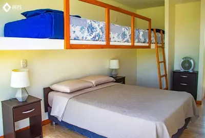 a bedroom with a bed and two bunk beds at HOP OHANA exclusiva en campo y playa en Chincha in Chincha Baja