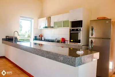a kitchen with a stainless steel refrigerator and a counter at HOP OHANA exclusiva en campo y playa en Chincha in Chincha Baja