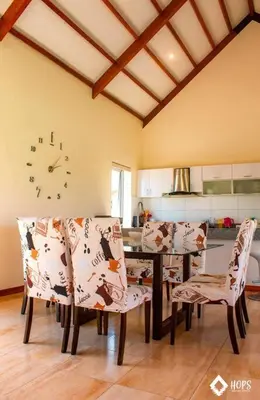 a dining room with a table and chairs and a clock at HOP OHANA exclusiva en campo y playa en Chincha in Chincha Baja