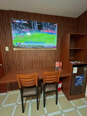 a dining room table with two chairs and a television at Hotel Los Arcos de Imperial in San Vicente de Cañete
