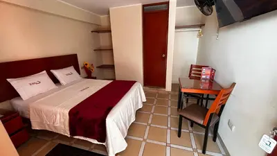 a small bedroom with a bed and a table at Hotel Los Arcos de Imperial in San Vicente de Cañete