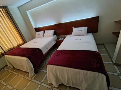 a room with two beds in a room at Hotel Los Arcos de Imperial in San Vicente de Cañete
