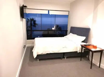 a bedroom with a bed and a window and a table at Espacio Luxury Apartments Malecón 2 in Lima